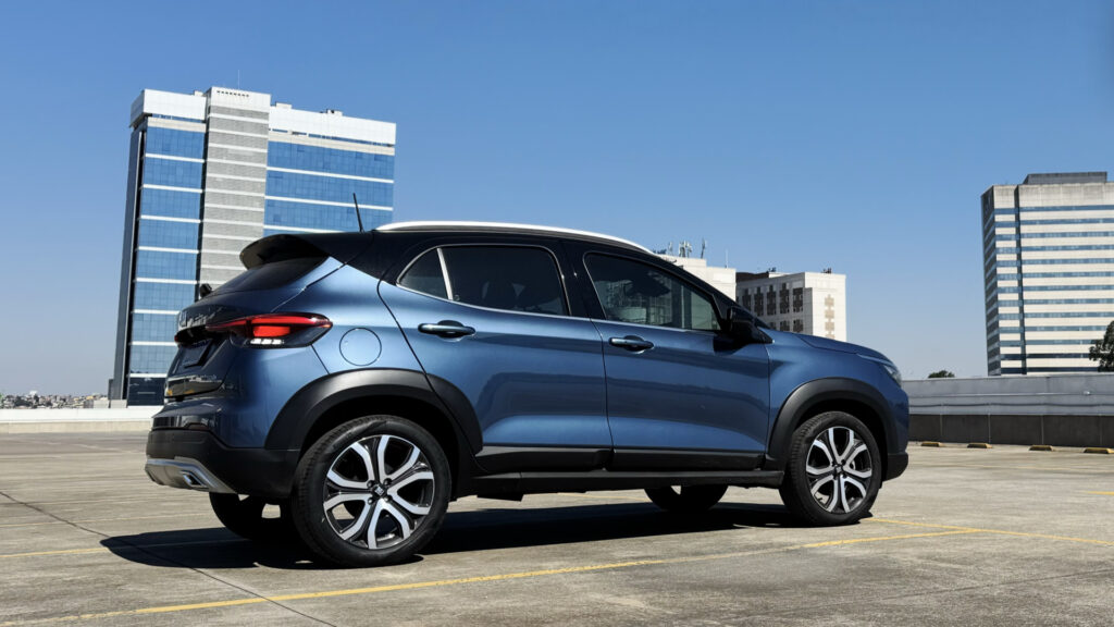 Fiat Pulse Hybrid azul visto de lado com o céu azul e prédios ao fundo